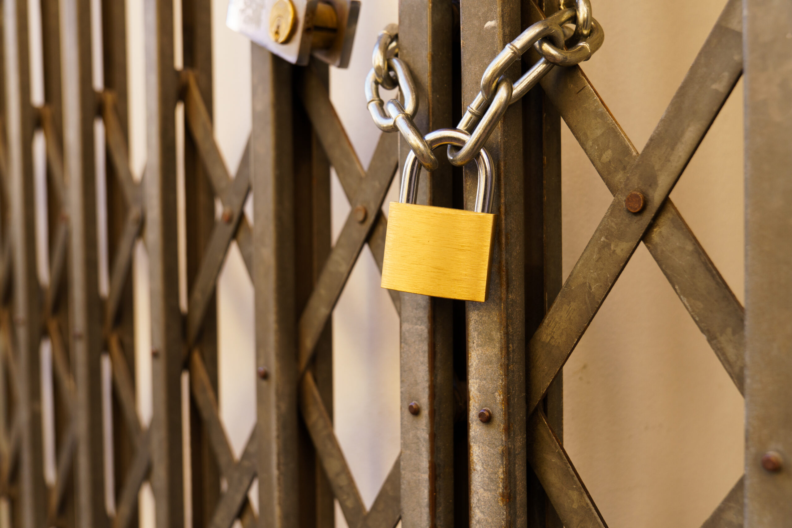 Metal door of a business closed with a padlock A metal door of a business closed with a padlock due to the crisis
