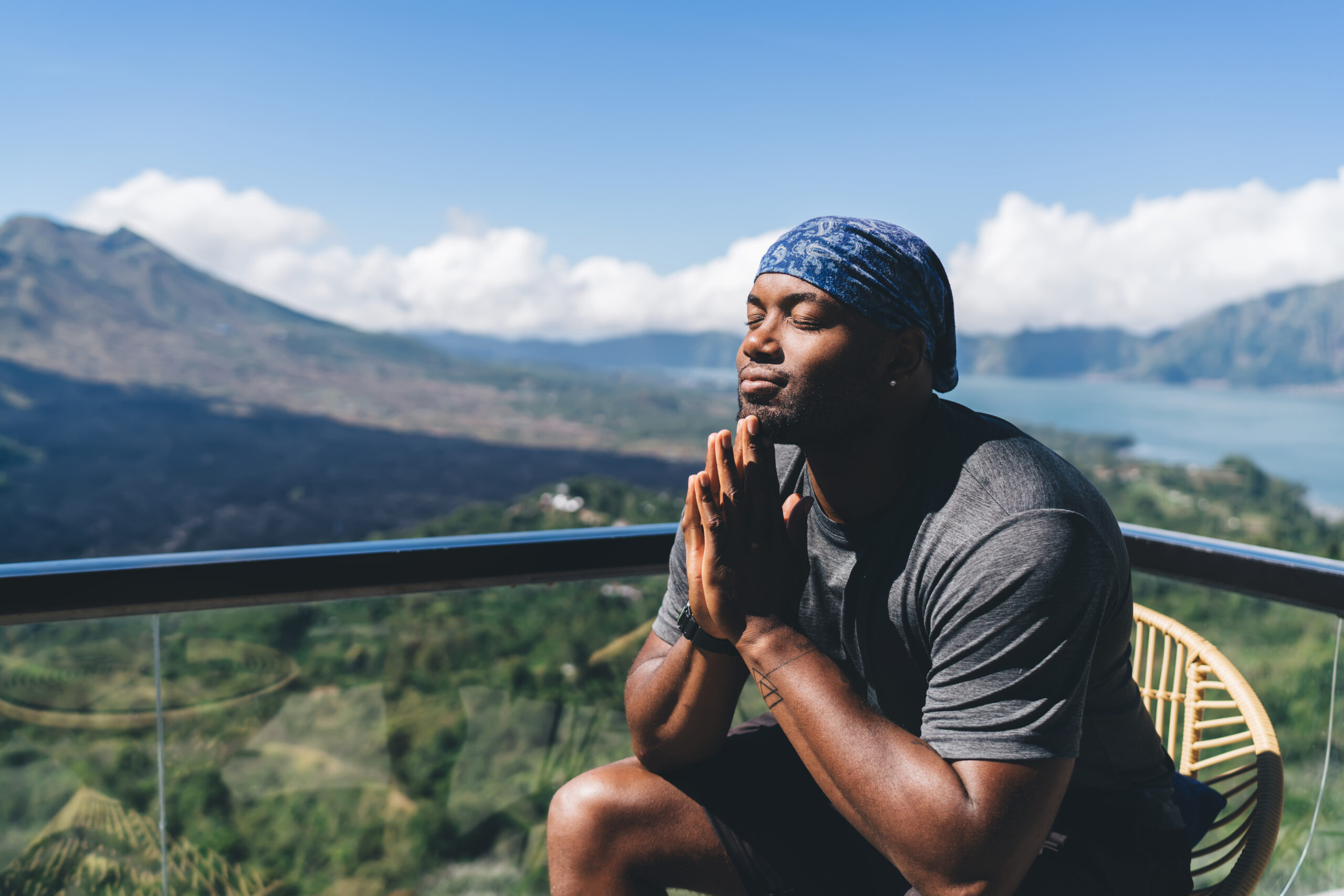 Calm black man sitting in highland with eyes closed