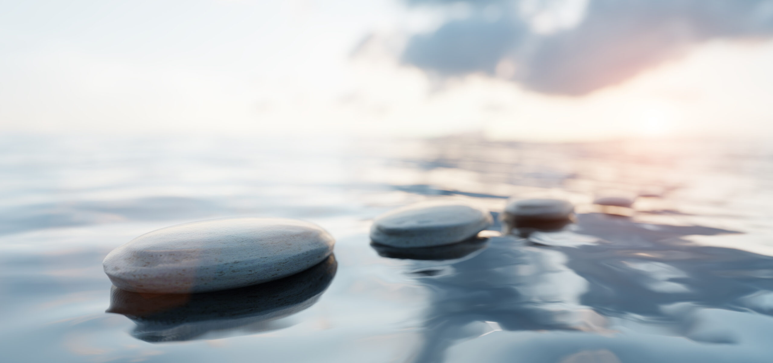 Zen stones on calm water at sunset. Spa wellness and harmony.